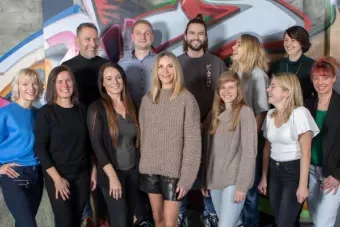 Teamfoto vor bunter Graffiti-Wand