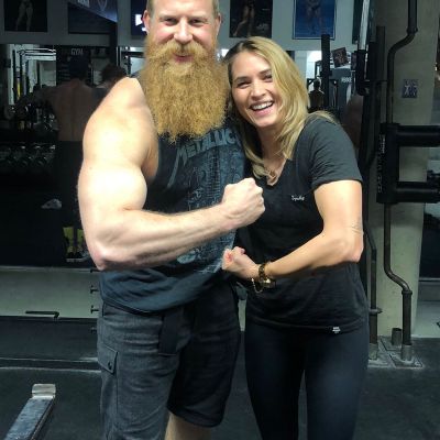 Zwei muskulöse Personen posieren im Fitnessstudio