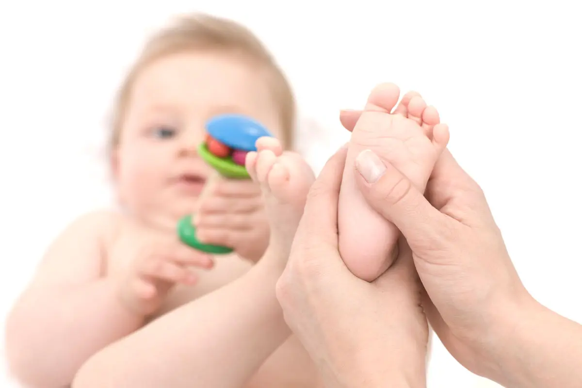 Baby liegt entspannt auf einer Behandlungsliege während einer physiotherapeutischen Behandlung.