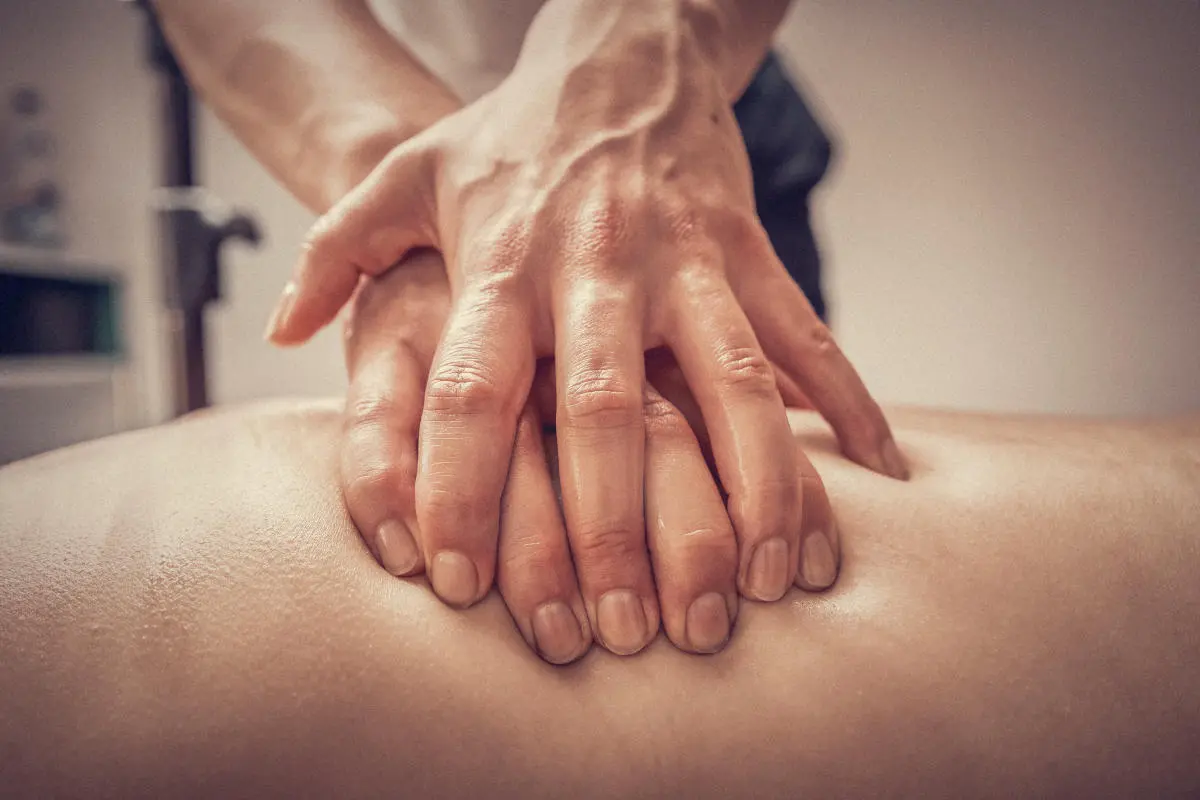 Therapeutin unterstützt Patientin bei einer Gleichgewichtsübung auf einer Trainingsmatte in der Physiotherapiepraxis.