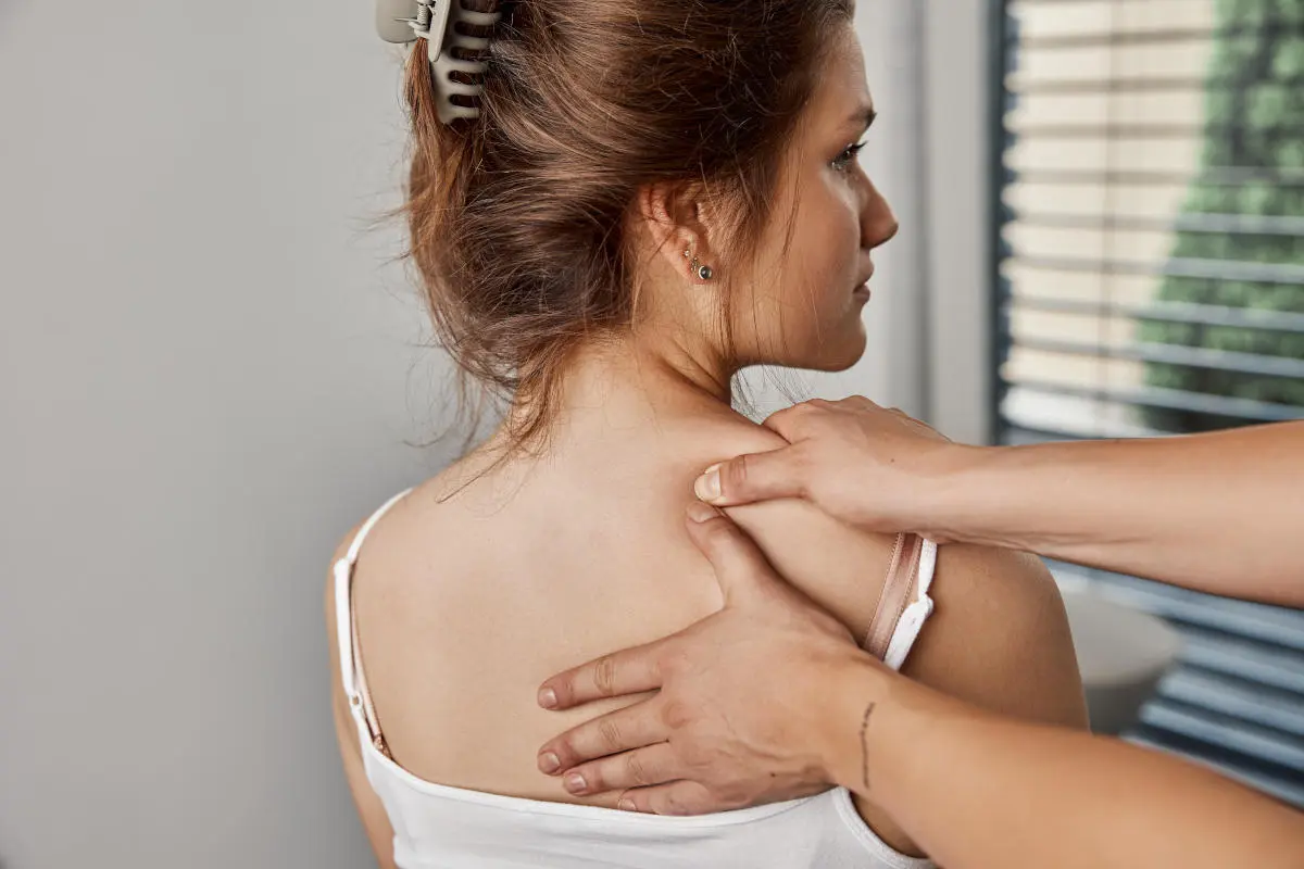 Therapeut führt eine Rückenmassage bei einer Patientin in der Physiotherapie-Praxis durch.