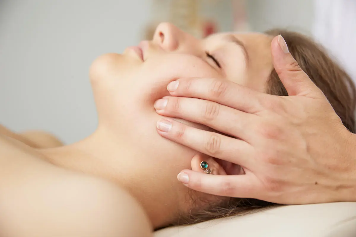 Therapeut führt eine Massage bei einer Patientin in der Physiotherapie-Praxis durch.
